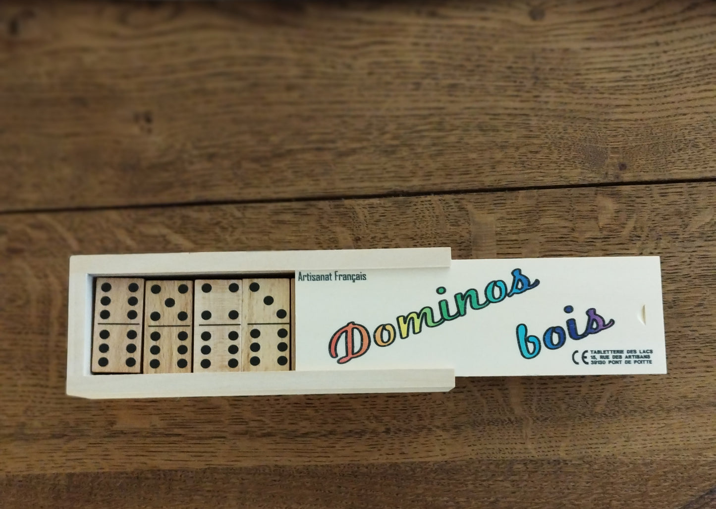 Photo de la boîte de dominos ouverte et laissant apparaitre les dominos en bois