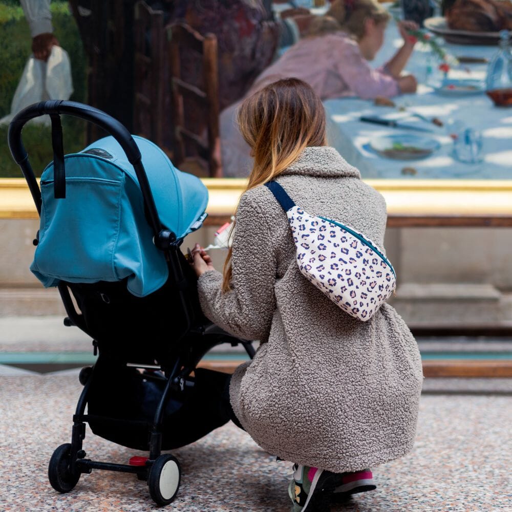 photo d'une maman portant une banane à langer et son bébé 
